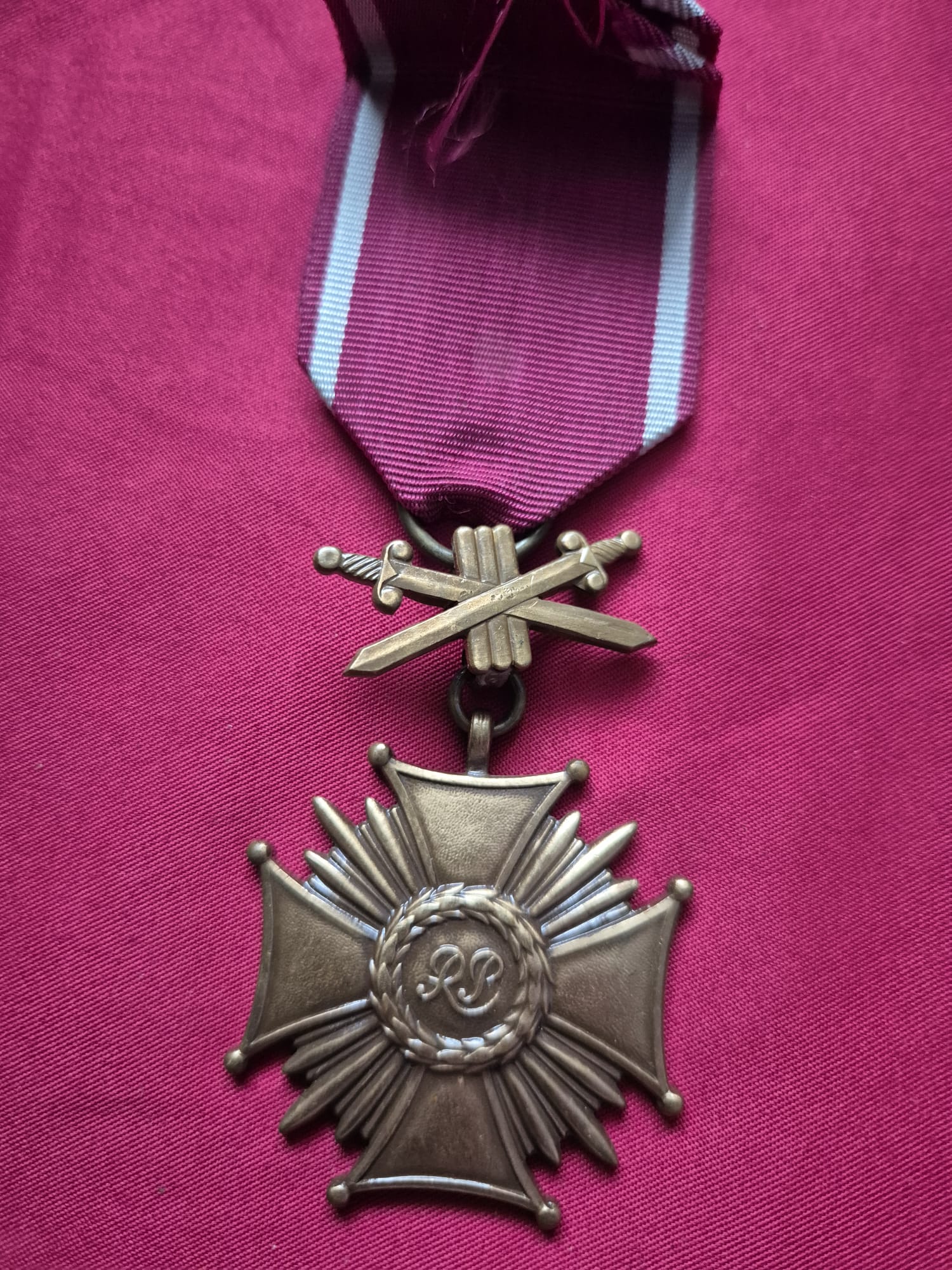 A Polish III RP Cross of Merit with crossed swords.