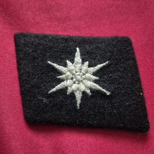 Embroidered SS Karstjäger collar tab with starburst emblem.
